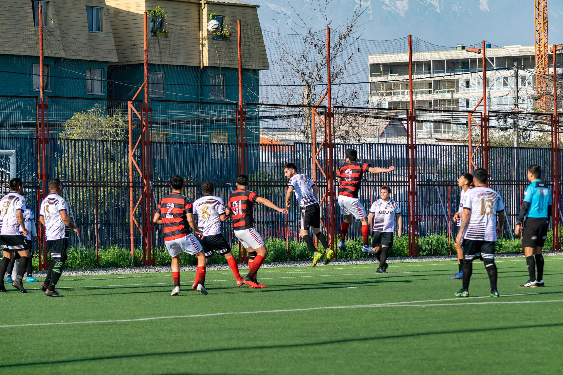 Duelo aéreo por el balón con la cordillera de fondo