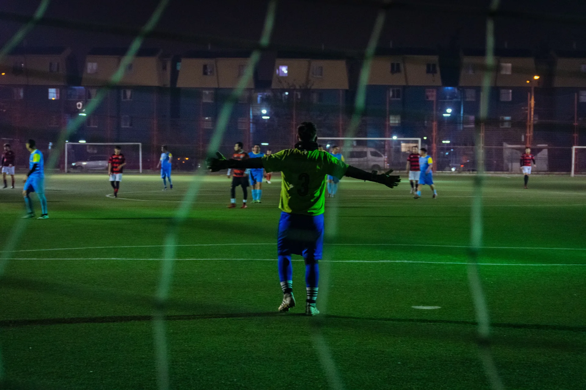 Arquero dirigiendo a su equipo en un partido nocturno