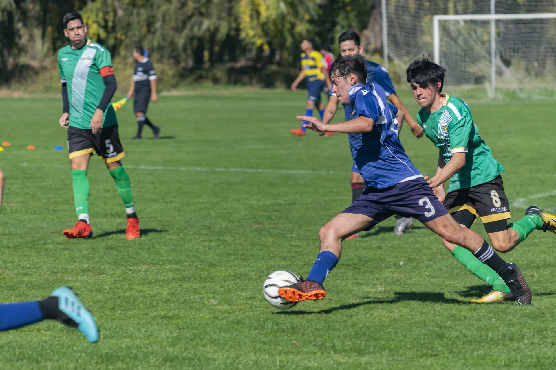 Jugador rematando al arco en un partido de fútbol